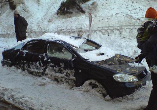 la neige est tombée sur une voiture du toit du balcon