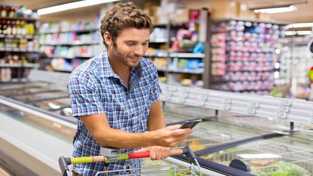 un homme avec un téléphone dans un supermarché